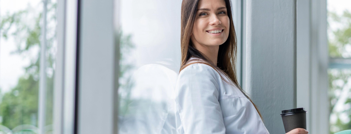 JPG-Marketing_20240815_smiling-woman-in-a-white-coat-relaxes-on-a-window-sill 